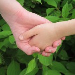 main dans la main avec feuilles vertes en fond